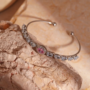 Detail of pink oval gemstone bracelet with pavé stones on natural stone backdrop