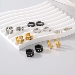 Detail of C-shaped titanium steel earrings in gold, silver and black with cubic zirconia
