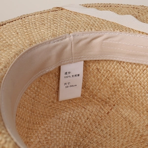 Detail of internal sweatband and 100% natural straw material label on flat top hat