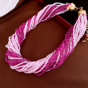 Detail showing multi-layer twisted seed bead necklace in pink shades and gold metal clasp