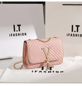 Detail showing pink quilted leather texture with gold V-metal buckle and tassel charm