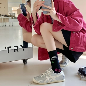 Close-up of metallic silver sneakers with white stripes and colorful graffiti socks