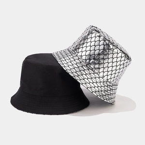 Close-up of metallic silver fish scale texture and plain black fabric on bucket hats