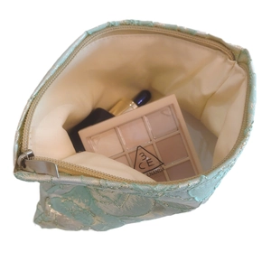 Elegant mint green small makeup bag with golden jacquard floral patterns and zipper