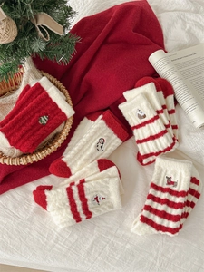 Detailed view of plush Christmas socks with festive snowman and puppy embroidery