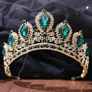 Detail of a golden bridal crown featuring teardrop green gems and clear rhinestones