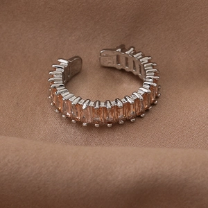 Detailed view of silver open ring featuring rectangular champagne zirconia on brown fabric