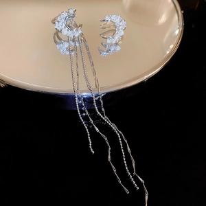 Detail of silver crescent moon clip earrings with long tassels and pearls on mirror