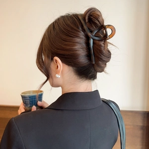Detail of elegant large tortoiseshell acetate claw clip securing hair in a back view
