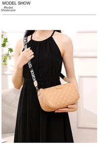 Detail view of khaki quilted shoulder bag with embroidered wide jacquard strap on model