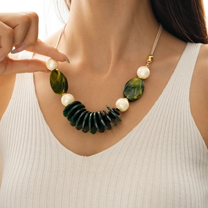 Detail of leather necklace featuring green resin oval pendant and white faux pearls