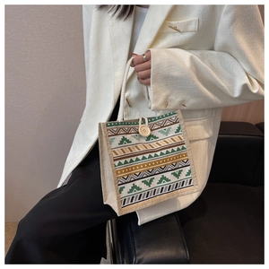Détail d'un sac en lin à motif ethnique avec poignée en coton et bouton en bois naturel