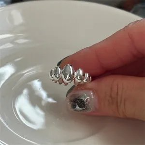 Close-up of a silver 925 bubble-shaped open ring with a high-polished metallic finish