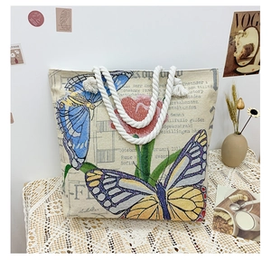 Detail of vintage canvas tote bag with butterfly embroidery and cotton rope handles