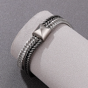 Detailed macro of two-tone silver and black braided stainless steel dragon bone chain bracelet