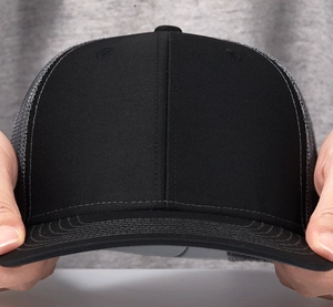 Close-up of the breathable black mesh material and cotton stitching on the trucker cap