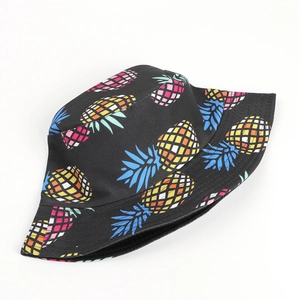 Reversible bucket hat with colorful tropical pineapple print on black cotton fabric
