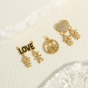 Macro shot of 18K gold plated boy girl pendants with clear crystals and LOVE lettering