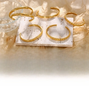 Detailed close-up of gold twist bangles with star patterns and sparkling zircon stones