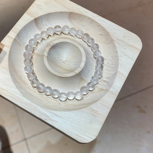 Macro detail of transparent white crystal beads with natural texture on a wooden tray