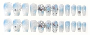 Close-up of blue and white gradient press-on nails with snowflakes and rhinestones