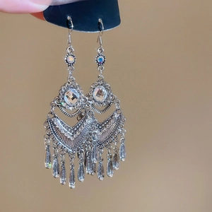 Macro detail of vintage silver flower earrings with tassels and transparent faceted gemstones
