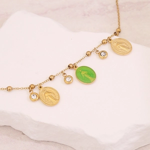 Golden Virgin Mary necklace set with green oval charms and rhinestones on marble