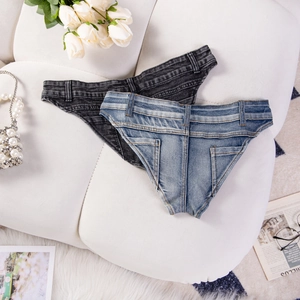 Flat lay di pantaloncini di jeans blu e grigio scuro su un divano con accessori moda