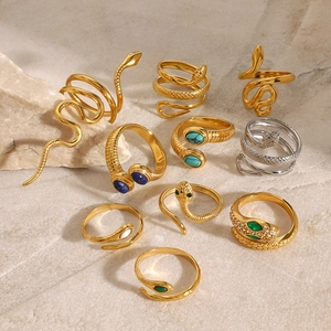 Snake rings set in gold and silver steel with turquoise stones on natural stone background