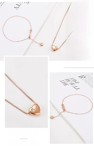 Detailed view of rose gold heart pendant necklace and bracelet set with small crystal