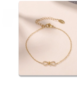 Détail d'un bracelet doré en acier inoxydable avec pendentif infini orné de zircons