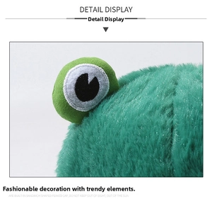 Detail display of green plush frog bucket hat showing soft faux fur and embroidered eyes