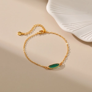 Dettaglio macro del bracciale placcato oro 18 carati con gemma ovale verde