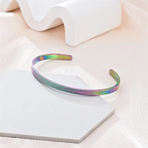 Primer plano de una pulsera rígida abierta en C de acero de titanio mate con efecto arcoíris.