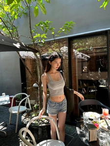 Graues bauchfreies Top mit U-Ausschnitt und hellblaue Denim-Shorts für einen Sommerlook