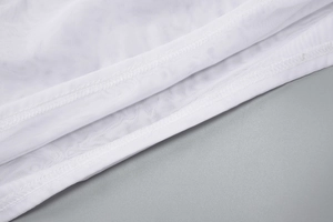 Vue macro du tissu en maille blanche montrant les coutures et la texture transparente
