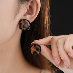 Gros plan de boucles d'oreilles carrées léopard avec bordure noire sur mannequin
