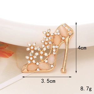Detail view of gold high heel charm with cat eye stone and rhinestones, size 4cm by 3.5cm