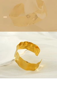 Macro detail of golden wide cuff bracelet featuring unique hammered texture finish