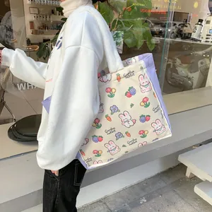Detail of canvas tote bag with rabbit patterns and purple trim with plush shoulder strap