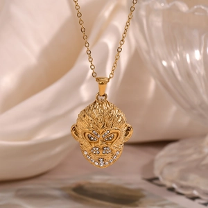 Gros plan d'un pendentif singe doré avec strass sur tissu en soie et fond de verre