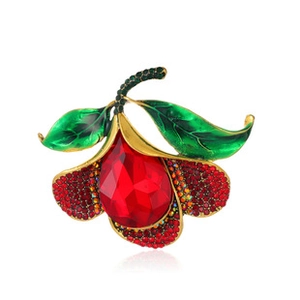 Detail of baroque brooch with red crystal teardrop and green enamel leaves on gold base