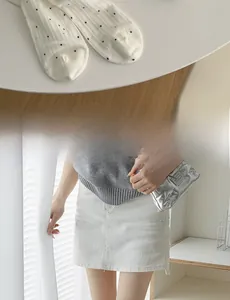 Détail de chaussettes en coton blanc à pois noirs et texture côtelée verticale