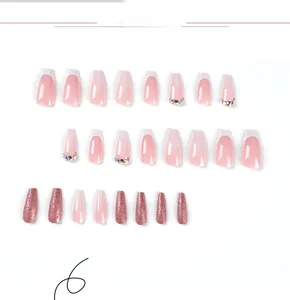Dettaglio delle unghie finte ballerina rosa e bianche con strass e glitter in oro rosa