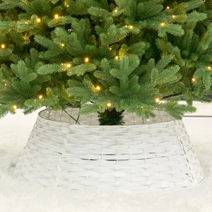 White faux rattan Christmas tree collar with warm LED lights on plush carpet