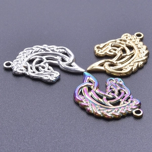 Macro shot of three Celtic knot dragon pendants in silver, bronze, and rainbow metal finishes