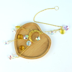 Golden moon and star crystal suncatcher on a wooden heart tray with rainbow beads