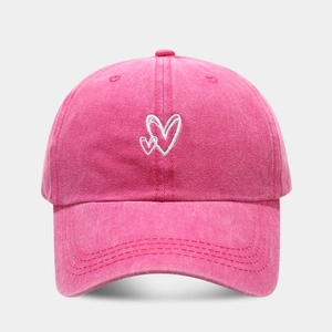 Close-up of rose red washed cotton baseball cap with white heart embroidery detail