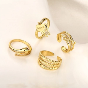 Detailed view of four adjustable gold-tone rings with heart charms and zircon stones