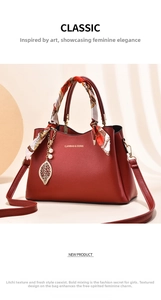 Detail of red lychee grain leather handbag with silk scarf handle and pearl leaf pendant